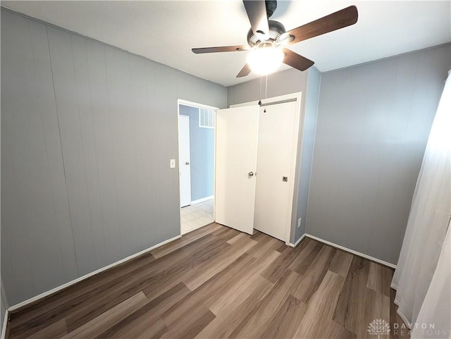 unfurnished bedroom featuring ceiling fan, a closet, and light hardwood / wood-style floors