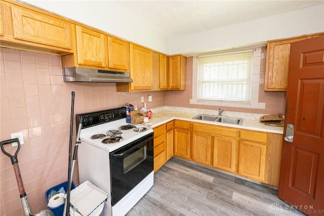 kitchen with decorative backsplash, sink, white electric range oven, and light hardwood / wood-style flooring