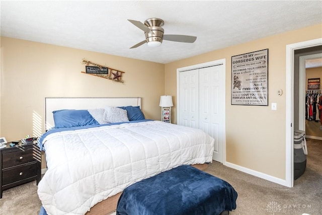 bedroom with ceiling fan, light carpet, and a closet