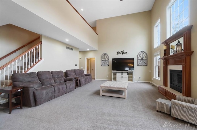 carpeted living room with a high ceiling