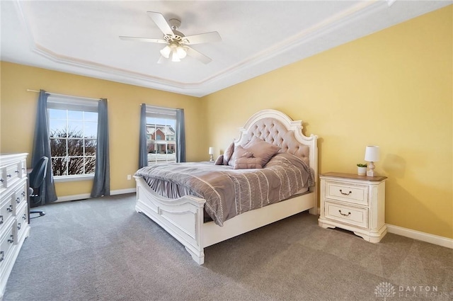 bedroom featuring carpet flooring, a tray ceiling, and ceiling fan