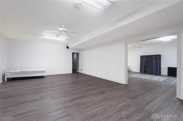 unfurnished room featuring a textured ceiling, lofted ceiling, ceiling fan, and dark hardwood / wood-style floors