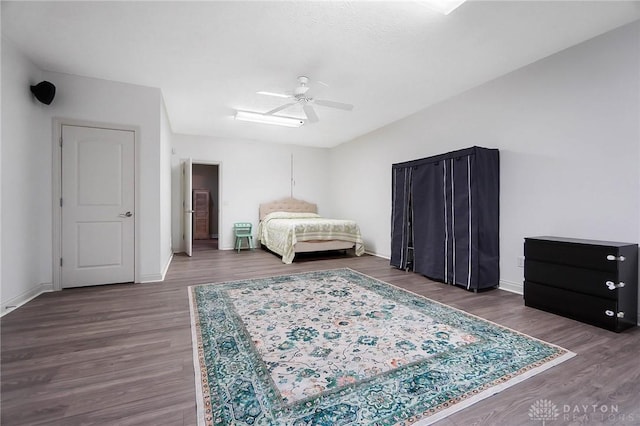 bedroom with dark hardwood / wood-style flooring and ceiling fan