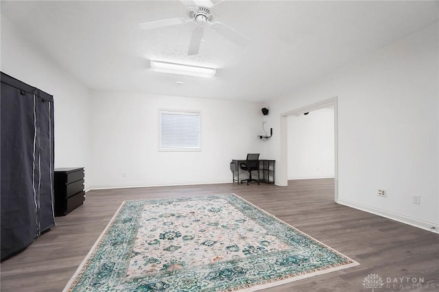 living room featuring ceiling fan and dark hardwood / wood-style floors