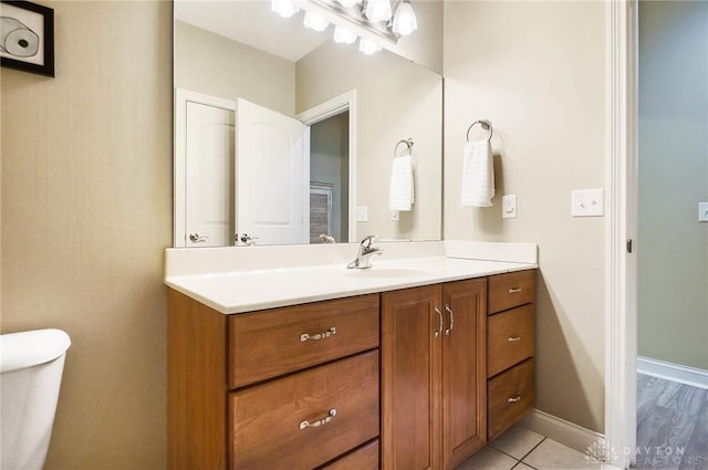 bathroom featuring tile patterned flooring, vanity, and toilet