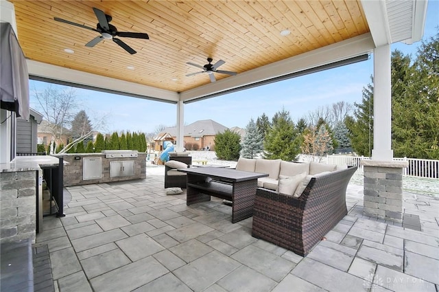 view of patio featuring an outdoor living space, an outdoor kitchen, ceiling fan, and grilling area