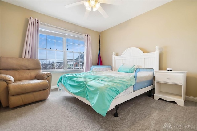 carpeted bedroom with ceiling fan and baseboards