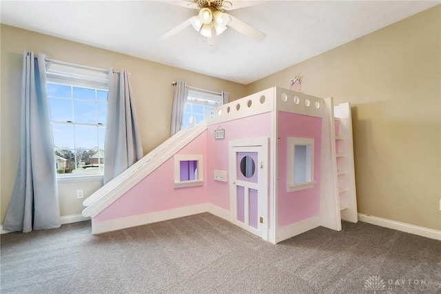 unfurnished bedroom featuring carpet, baseboards, and a ceiling fan