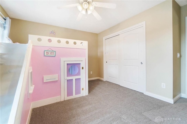 unfurnished bedroom with baseboards, a closet, a ceiling fan, and light colored carpet