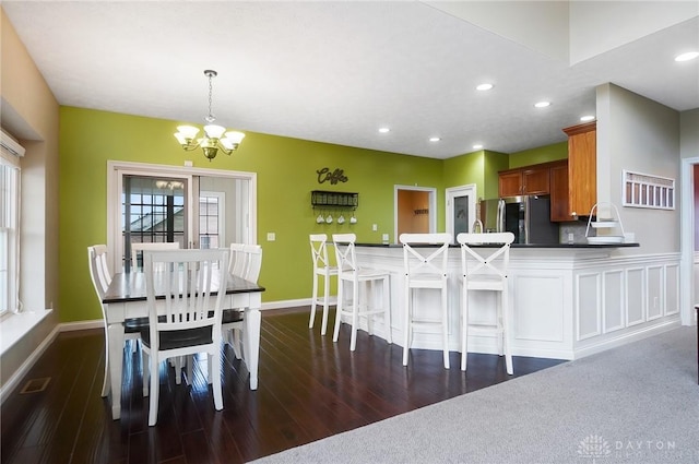 dining room featuring a chandelier, dark wood-style flooring, and baseboards