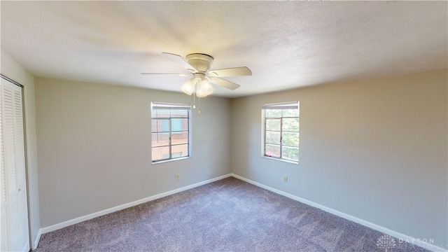 carpeted empty room with ceiling fan and a textured ceiling