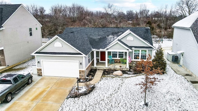 view of front of house with a porch, a garage, and central air condition unit