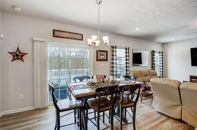 dining space with hardwood / wood-style flooring and an inviting chandelier