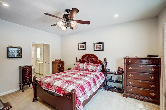 bedroom with light colored carpet, ensuite bath, and ceiling fan