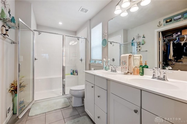 bathroom featuring tile patterned floors, vanity, an enclosed shower, and toilet