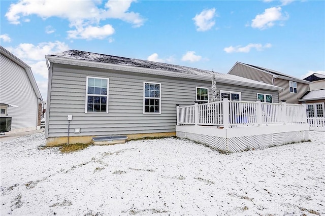 snow covered rear of property featuring a deck