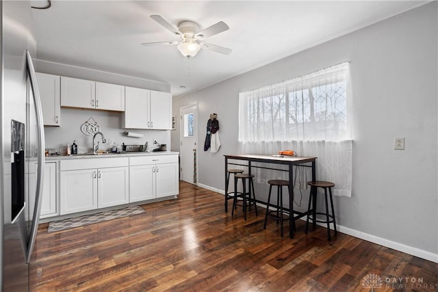 kitchen featuring stainless steel fridge with ice dispenser, white cabinetry, dark hardwood / wood-style flooring, and ceiling fan