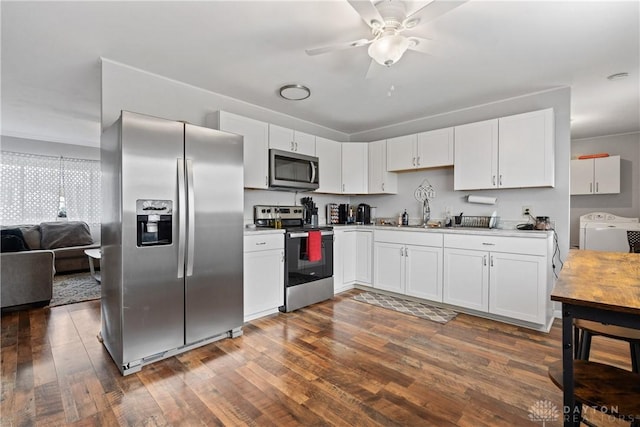 kitchen featuring white cabinets, stainless steel appliances, dark hardwood / wood-style floors, and independent washer and dryer