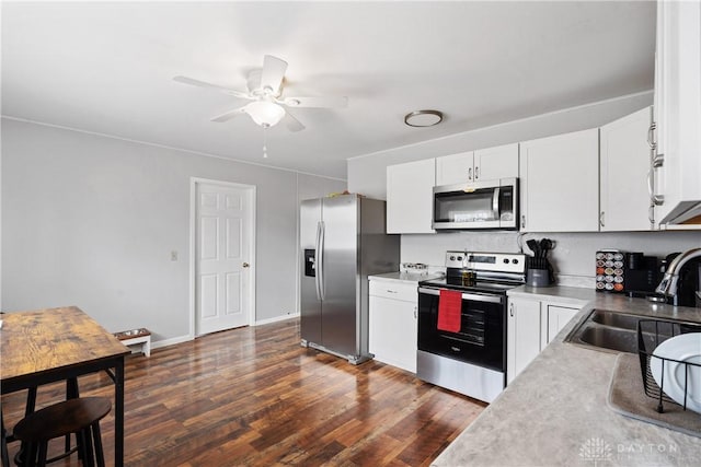 kitchen with dark wood-type flooring, white cabinets, sink, ceiling fan, and stainless steel appliances