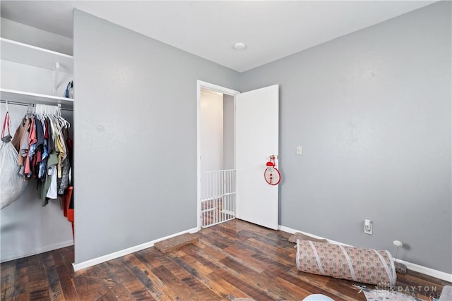 unfurnished bedroom featuring dark wood-type flooring and a closet