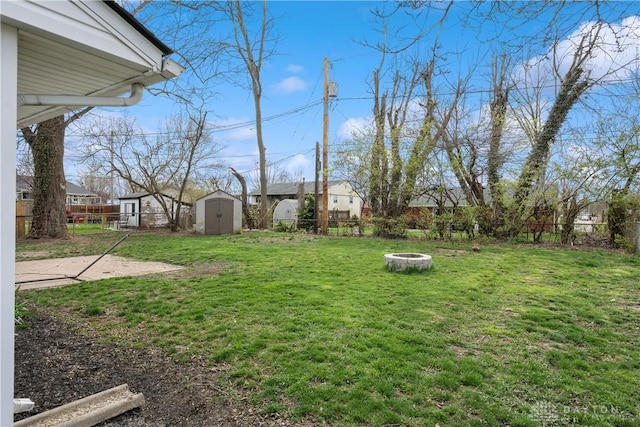 view of yard featuring a shed and an outdoor fire pit