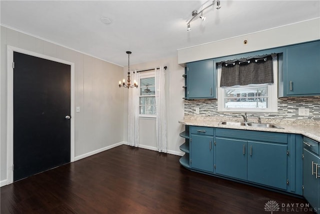 kitchen with sink, hanging light fixtures, an inviting chandelier, dark hardwood / wood-style floors, and blue cabinets