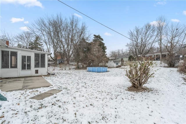 snowy yard with a sunroom