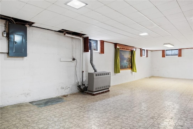 basement featuring electric panel and heating unit