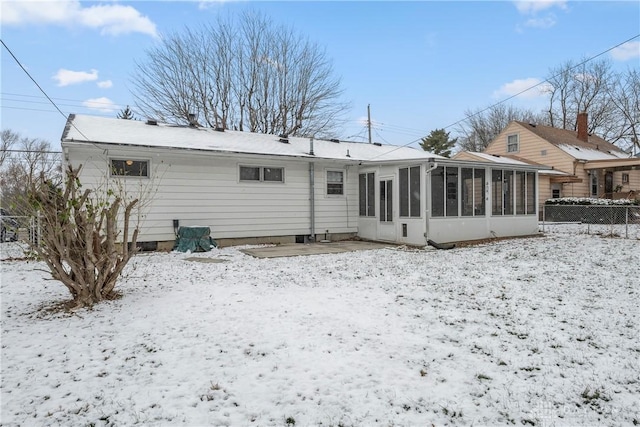 snow covered house with a sunroom