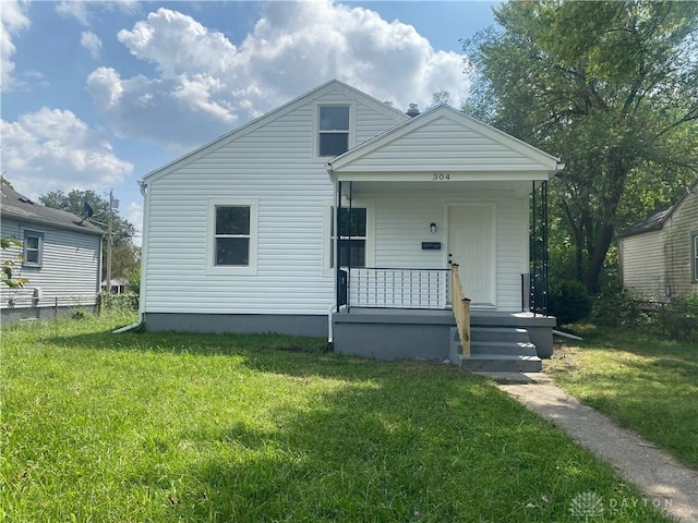 bungalow-style home with covered porch and a front lawn