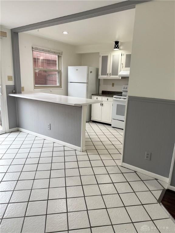 kitchen with kitchen peninsula, light tile patterned floors, white cabinets, and white appliances