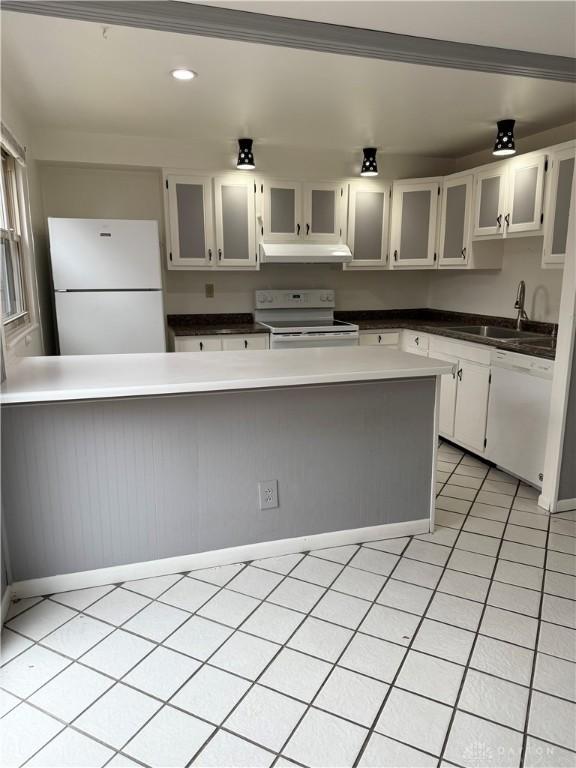 kitchen featuring white cabinets, light tile patterned floors, white appliances, and sink