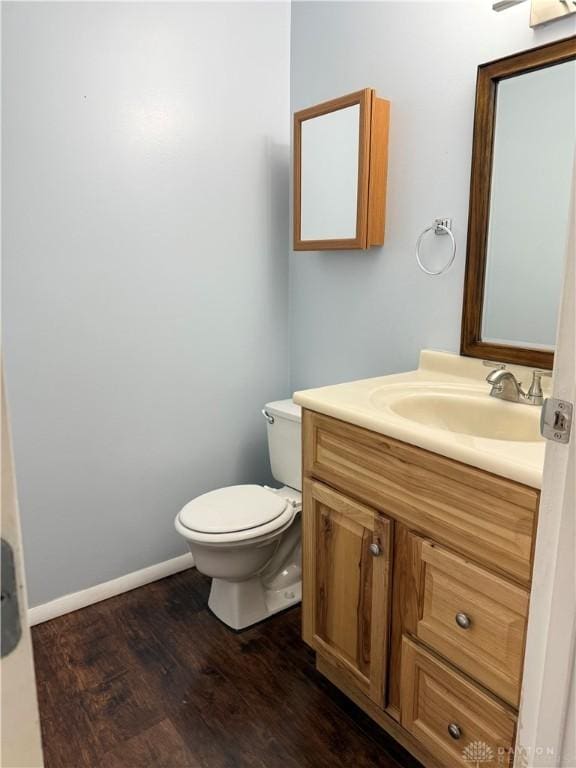 bathroom with hardwood / wood-style flooring, vanity, and toilet