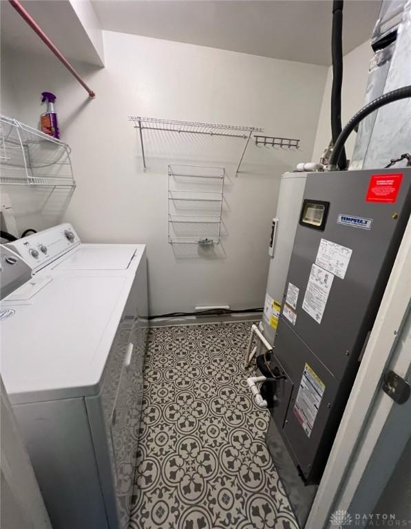 laundry room with heating unit and washer and clothes dryer