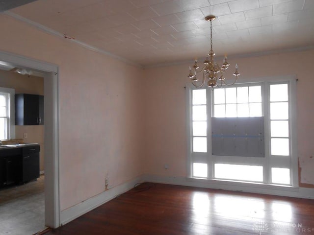 unfurnished dining area featuring a chandelier, crown molding, and wood-type flooring