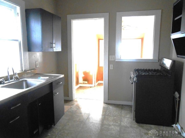 kitchen featuring sink, a healthy amount of sunlight, black range, and ceiling fan