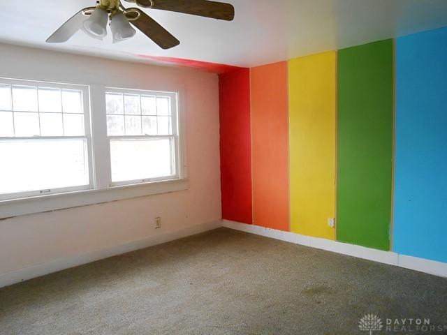 unfurnished room featuring ceiling fan and carpet flooring