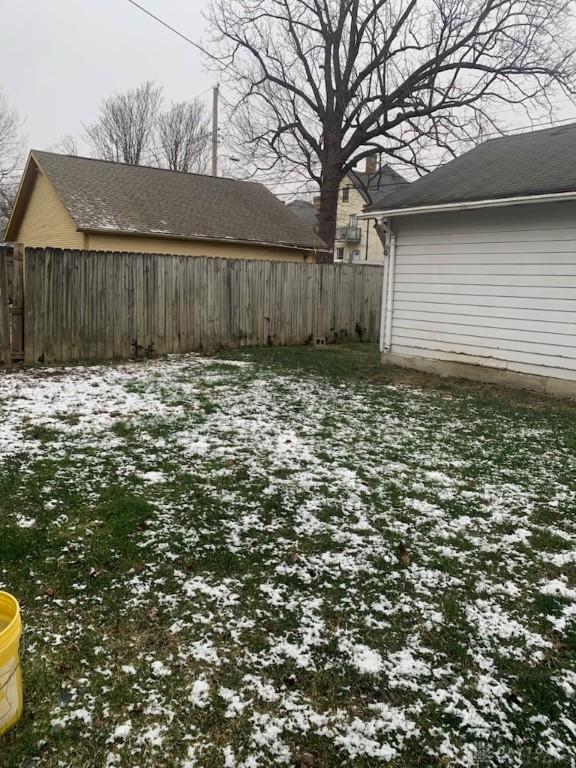 yard covered in snow featuring fence