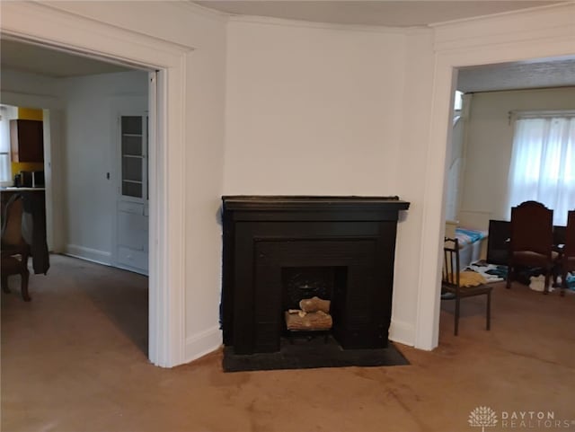 room details with baseboards, ornamental molding, a fireplace with flush hearth, and carpet