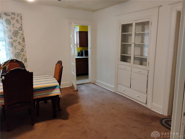 carpeted dining area with baseboards