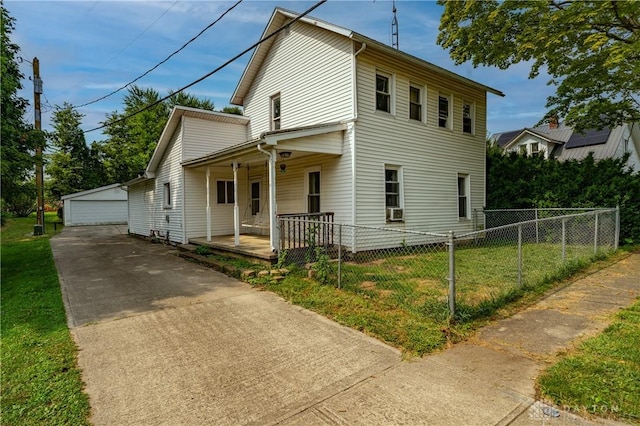 view of front of property featuring covered porch, an outbuilding, a garage, and a front yard