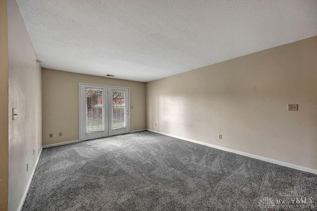 empty room with carpet floors and a textured ceiling