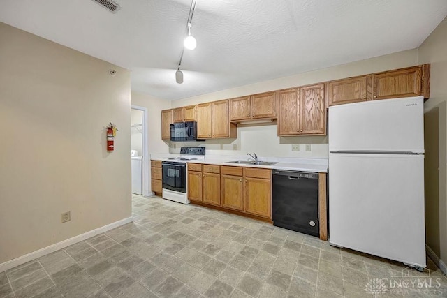 kitchen with sink, black appliances, and washer / dryer