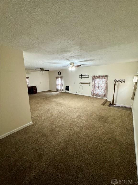 unfurnished living room with ceiling fan, carpet floors, a textured ceiling, and heating unit