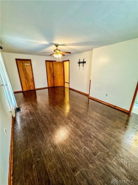 empty room featuring ceiling fan and dark wood-type flooring