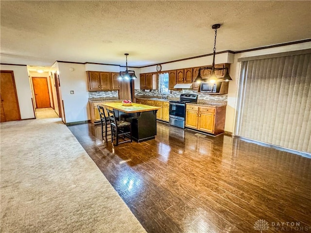 kitchen featuring appliances with stainless steel finishes, a textured ceiling, pendant lighting, and a breakfast bar area