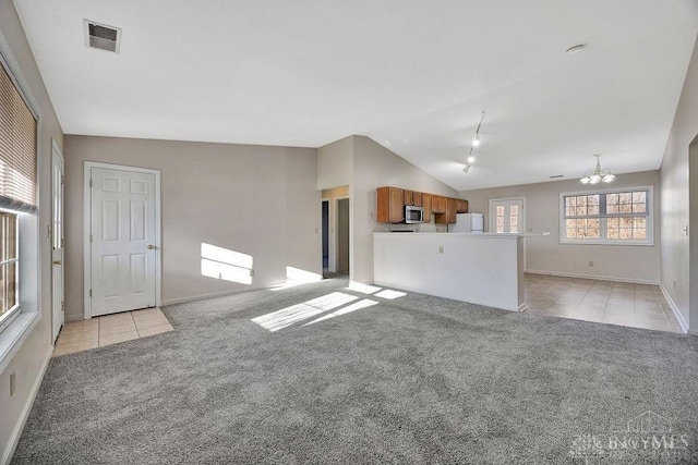 unfurnished living room with light tile patterned flooring, light carpet, visible vents, vaulted ceiling, and an inviting chandelier