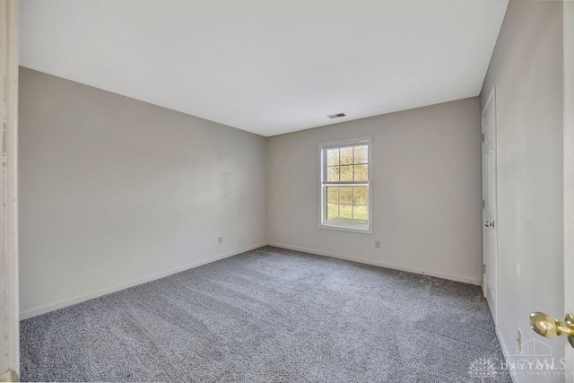 carpeted empty room with visible vents and baseboards