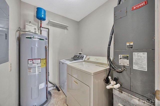 washroom with laundry area, electric water heater, heating unit, a textured ceiling, and separate washer and dryer