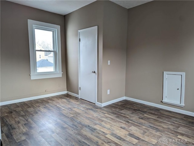 unfurnished room with dark wood-type flooring